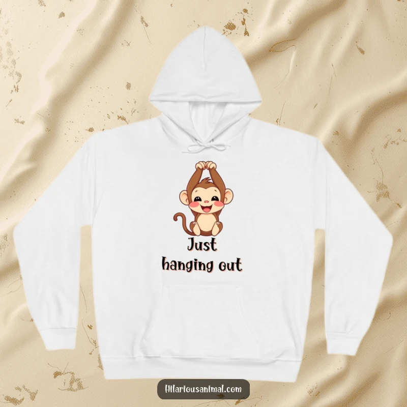 Funny monkey cub hoodie, comfortably hanging upside down with a delightful chuckle, ideal for cozy and humorous wear.