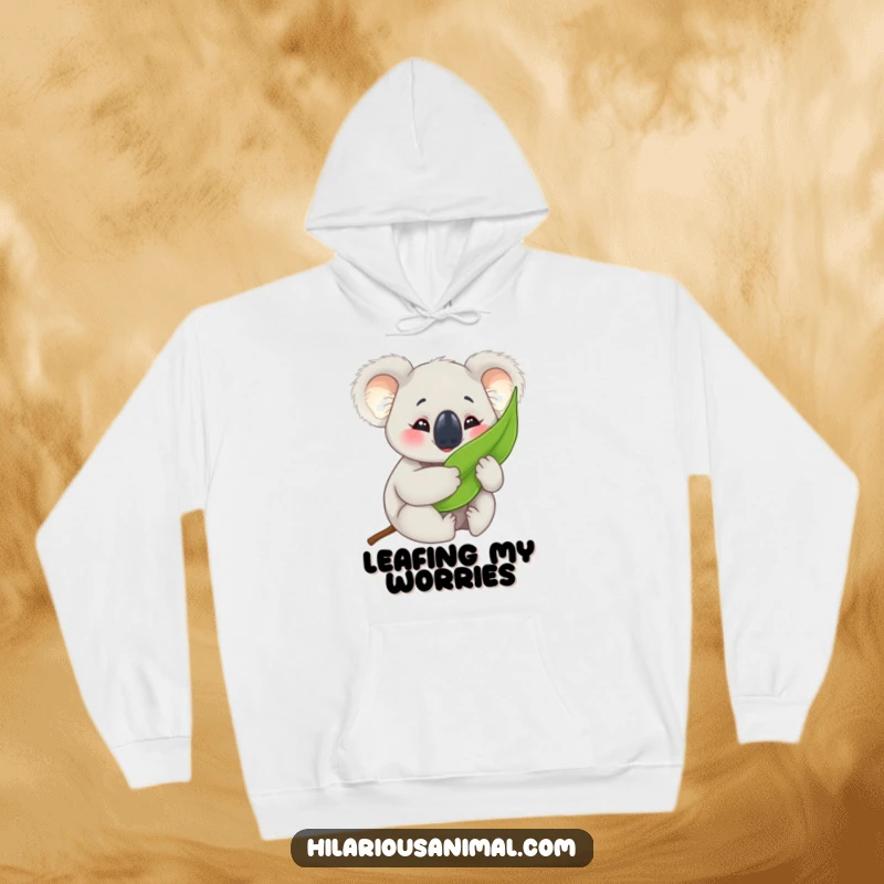 Funny koala cub hoodie, comfortably hugging a eucalyptus leaf with crinkled eyes, ideal for cozy and humorous relaxation.